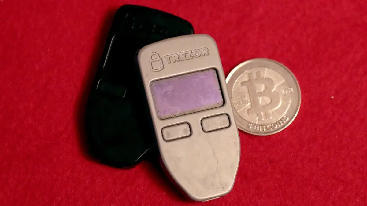 Two hardware wallets and a physical bitcoin coin