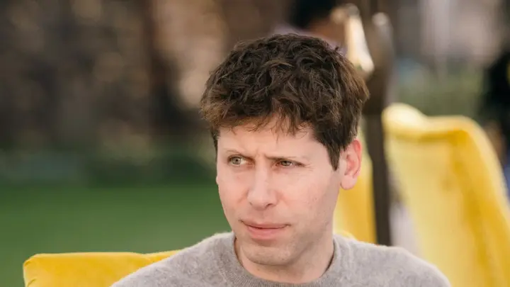 Sam Altman seated at an outdoor table